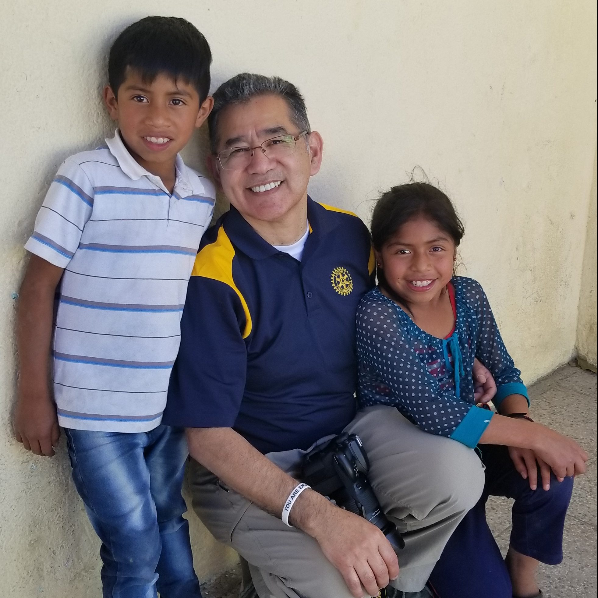 Man standing with two children smiling